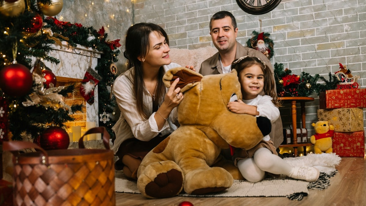 A family sitting on the floor in front of a christmas tree